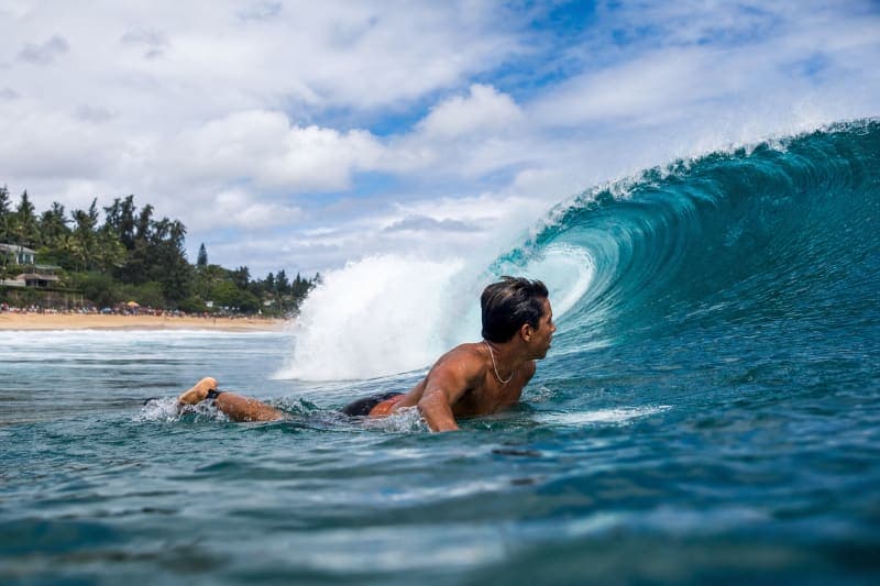 Surfer paddling toward an Oʻahu break